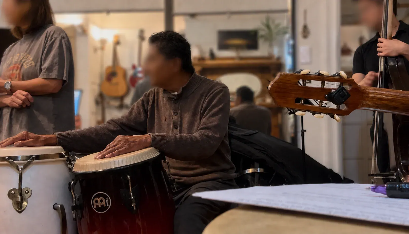 Musicians rehearsing with congas, upright bass, and guitar