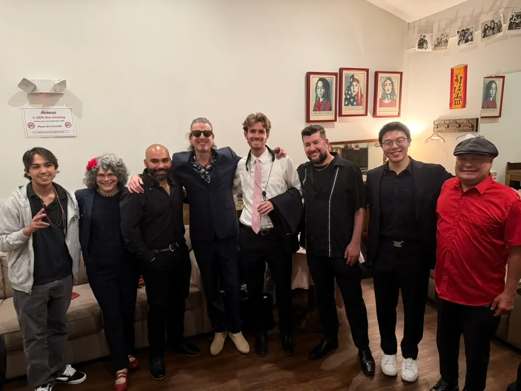Eight Guajirón musicians standing together in a rehearsal room